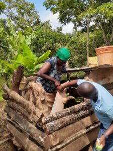 Anande and extension worker Jimmy inspecting her new pig